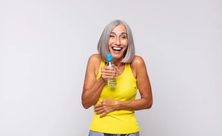 woman in yellow holding water bottle