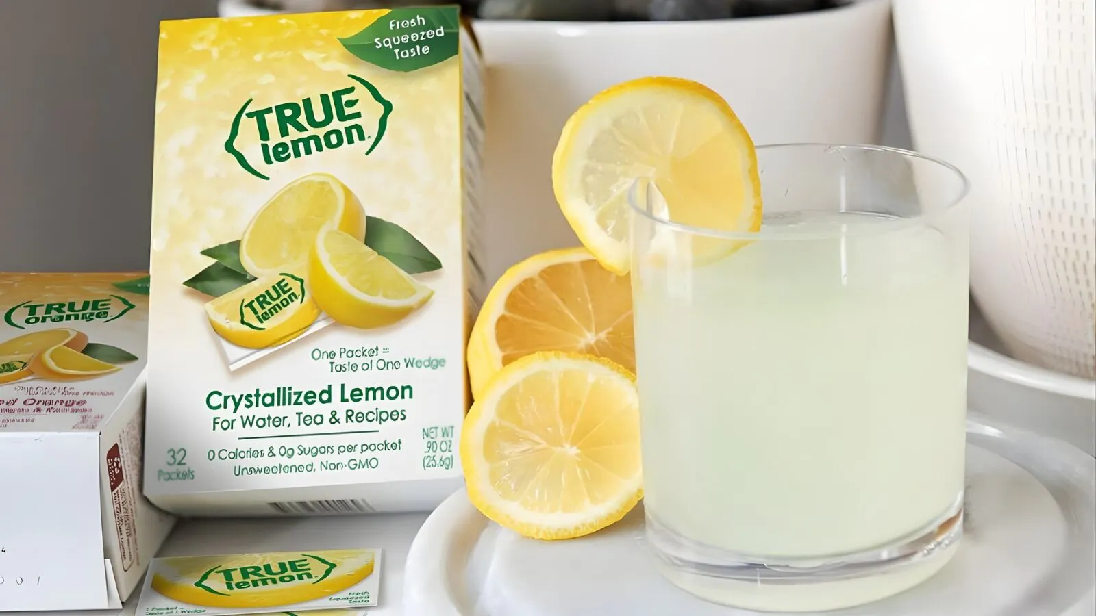 Box of True Lemon packets next to a glass of lemon water.