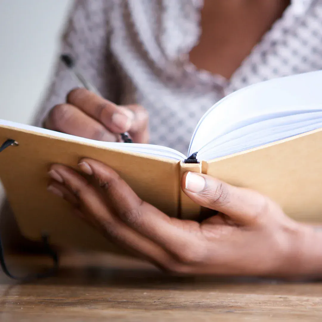 A woman writing in a notebook.