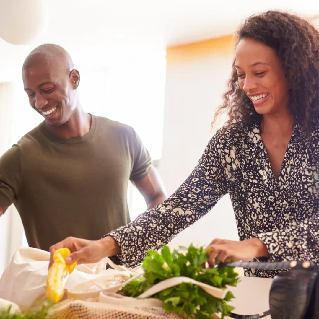 A man and a woman are cooking in a kitchen.
