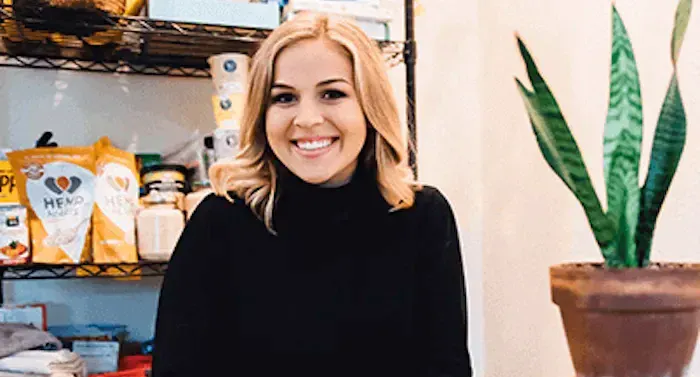 A blonde woman in a black sweater is smiling.