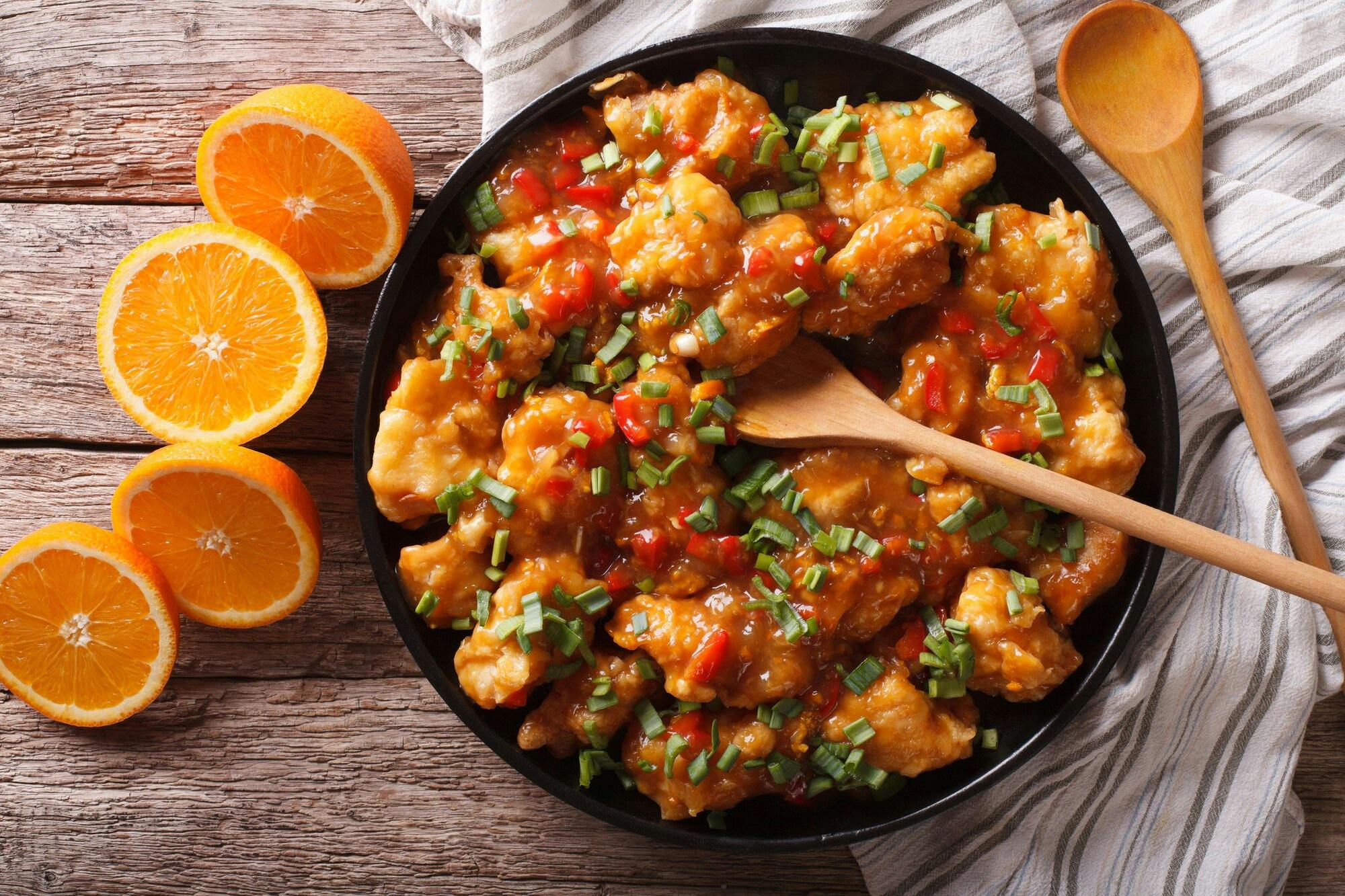 orange chicken in sweet and sour sauce on a plate close-up on the table. horizontal view from above