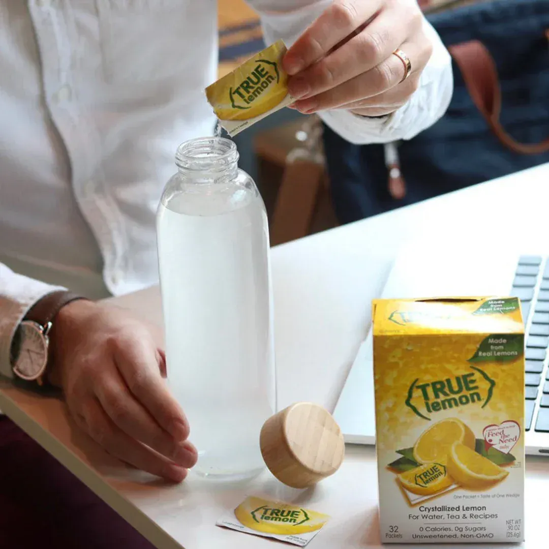 A man pours a packet of True Lemon into his water bottle.