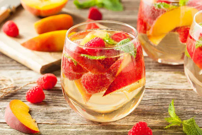 3 glasses of True Citrus Champagne Punch among slices of fruit.
